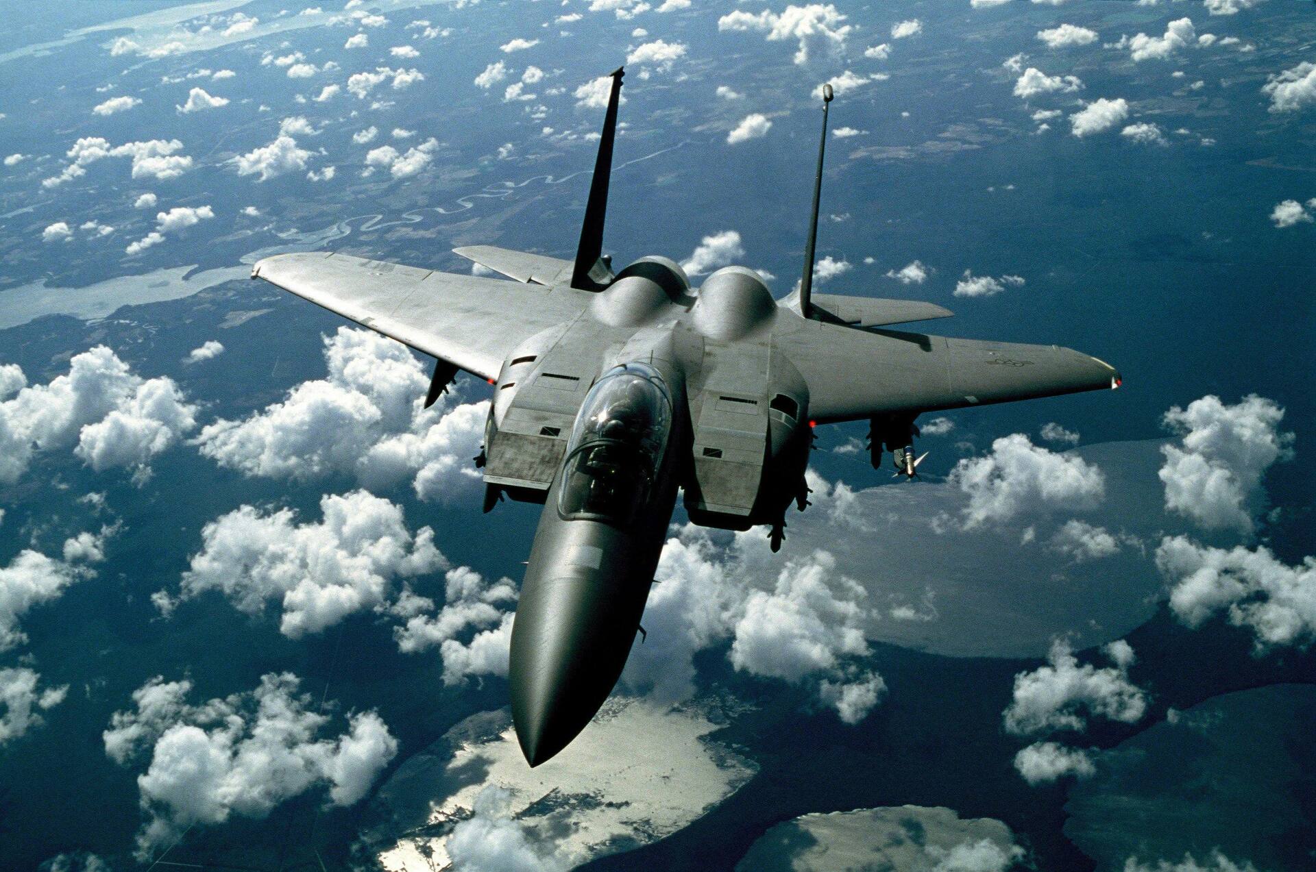 Fighter jet climbing through white clouds — evoking the aerial sequences of Top Gun